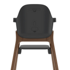 Rear view of a high chair with a dark gray molded seat and a natural wood frame, shown on a solid white background.