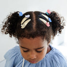 Child with styled hair featuring colorful hair clips against a light background