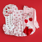 Children's outfit with cherry design on a red background