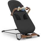 A modern baby bouncer chair with a black fabric seat cover, wooden handlebar accents, and a black metal support frame, shown on a plain white background.