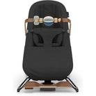 A high-terrain baby seat in black fabric with light wood accents and a matching black and wood headrest attachment, shown against a plain white background.