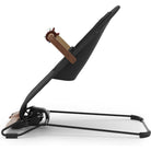 A modern baby bassinet with a black fabric seat, brown adjustable support straps, and a black metal frame, shown from a side profile on a white background.