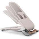 A beige baby support seat with a breathable mesh backrest and a dark metal frame, shown on a clean white background.