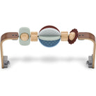 A wooden baby sensory toy with a curved natural wood frame, featuring a mint green square, a blue quilted oval, a brown textured oval, and light wood cylindrical pieces on a white background.