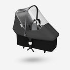 Black baby stroller with transparent rain cover on a white background