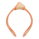 Beige and coral headband on a white background