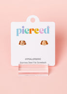 Earring packaging with 'pierced' branding on a pink background