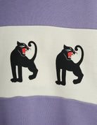 A lavender purple with a repeating pattern of black cartoon cats.