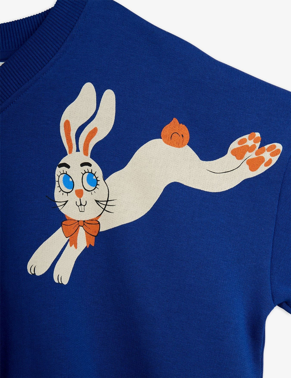 A close-up of a royal blue crewneck sweatshirt featuring a cartoon graphic of a white rabbit wearing an orange bow tie and carrying an orange acorn.