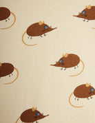 A close-up of a fabric pattern featuring cartoon brown mice with blue eyes and tan tails on a warm cream background.
