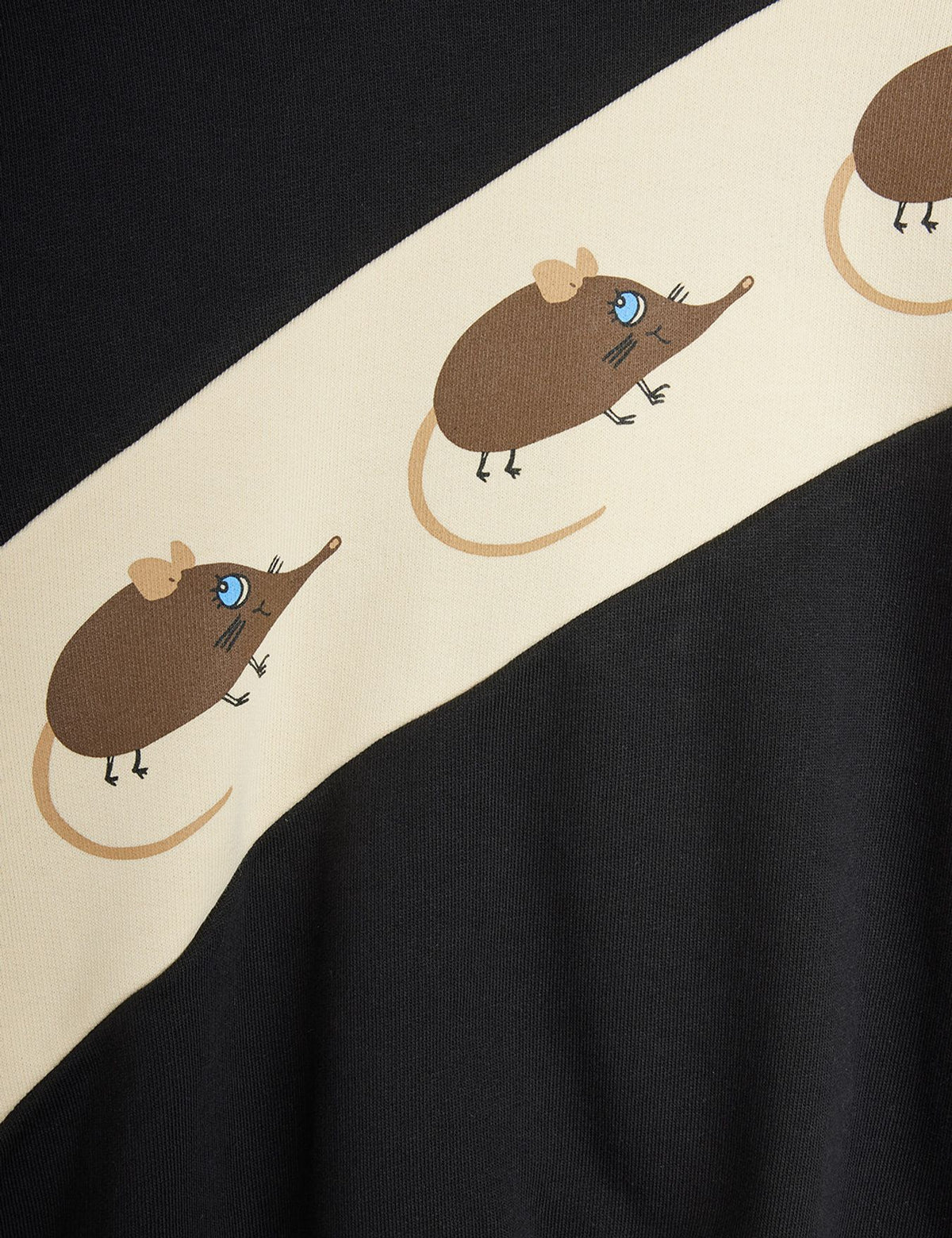 Close-up of a black garment with a wide cream diagonal band featuring cartoon brown mice with blue eyes.