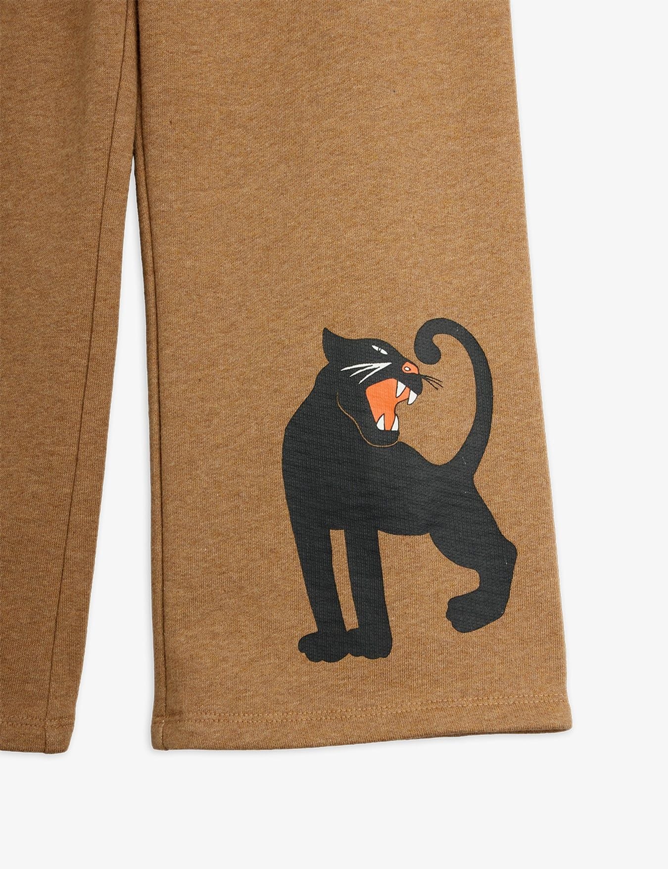 Close-up of tan heathered pants with a black panther graphic and orange mouth detail on the leg, shown against a light gray background.