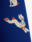 A close-up of a dark blue garment featuring a cartoon rabbit graphic in white with blue eyes, orange accents, and a small bow tie.