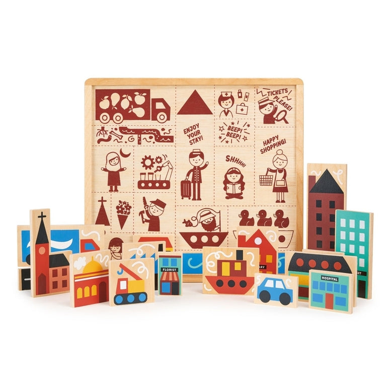 A close-up, top-down view of the Mentari Wooden Town Puzzle showing colorful, chunky wooden puzzle pieces partially placed in their tray, featuring buildings, a blue car, and illustrated characters with text reading "Tickets Please," "Shhhh!," and "Happy Shopping!"