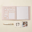 Open planner with pre-printed pages and a pen on a light beige background