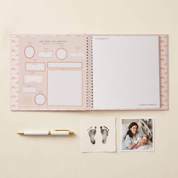 Open planner with pre-printed pages and a pen on a light beige background