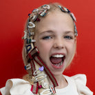 Young girl with a decorative headband against a red background