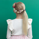 Child with styled hair in pigtails against a green background