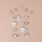 Decorative hair clips with angel and star designs on a beige background