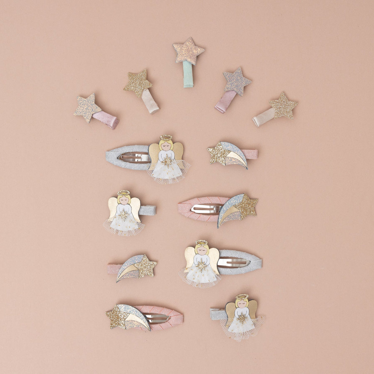Decorative hair clips with angel and star designs on a beige background