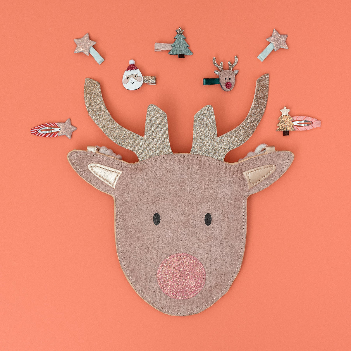 Decorative reindeer head with small Christmas-themed items on an orange background
