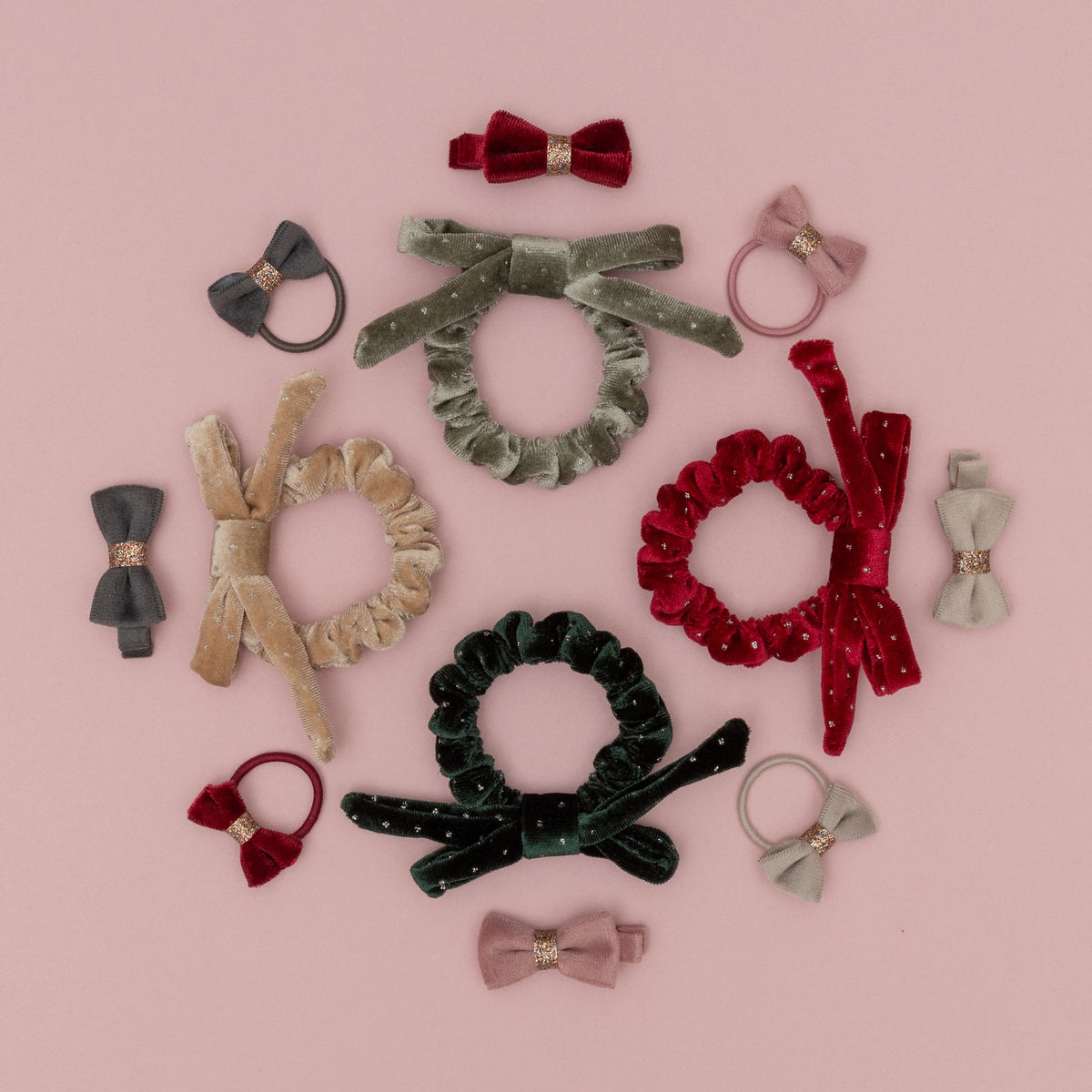 Collection of hair accessories including bows, scrunchies, and headbands on a pink background