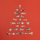 Collection of decorative hair clips arranged in a Christmas tree shape on a red background