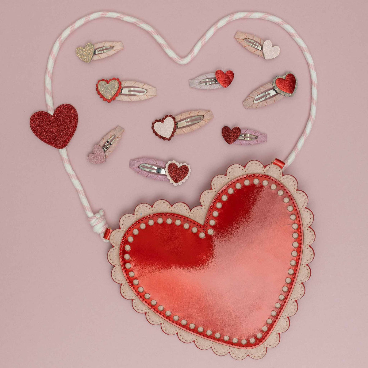 Heart-shaped hair accessories with decorative elements on a pink background