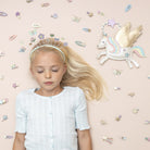 Young girl with butterfly hair clips on a plain background