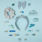 Collection of blue and white hair accessories on a light blue background