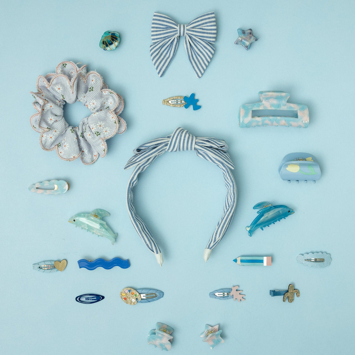 Collection of blue and white hair accessories on a light blue background