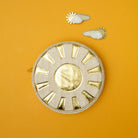 Decorative circular piece with gold accents on an orange background