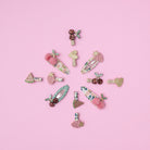 Collection of colorful hair clips on a pink background