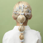 Person with a braid wearing colorful hair clips on a green background