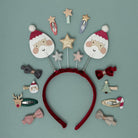Red headband with Christmas-themed hair accessories on a green background
