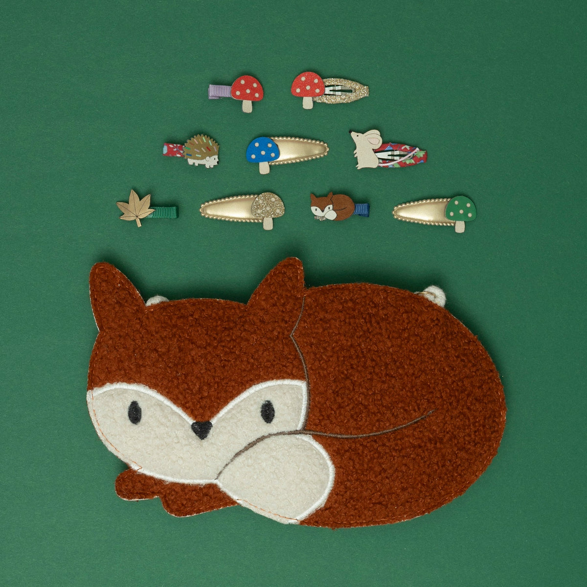 Embroidered fox patch with various nature-themed pins on a green background
