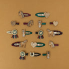 Collection of horse-themed hair clips on a brown background