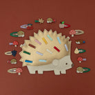 Hedgehog-shaped hair clip with various small hair clips on a brown background