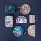 Collection of colorful children's bags and pouches on a dark background