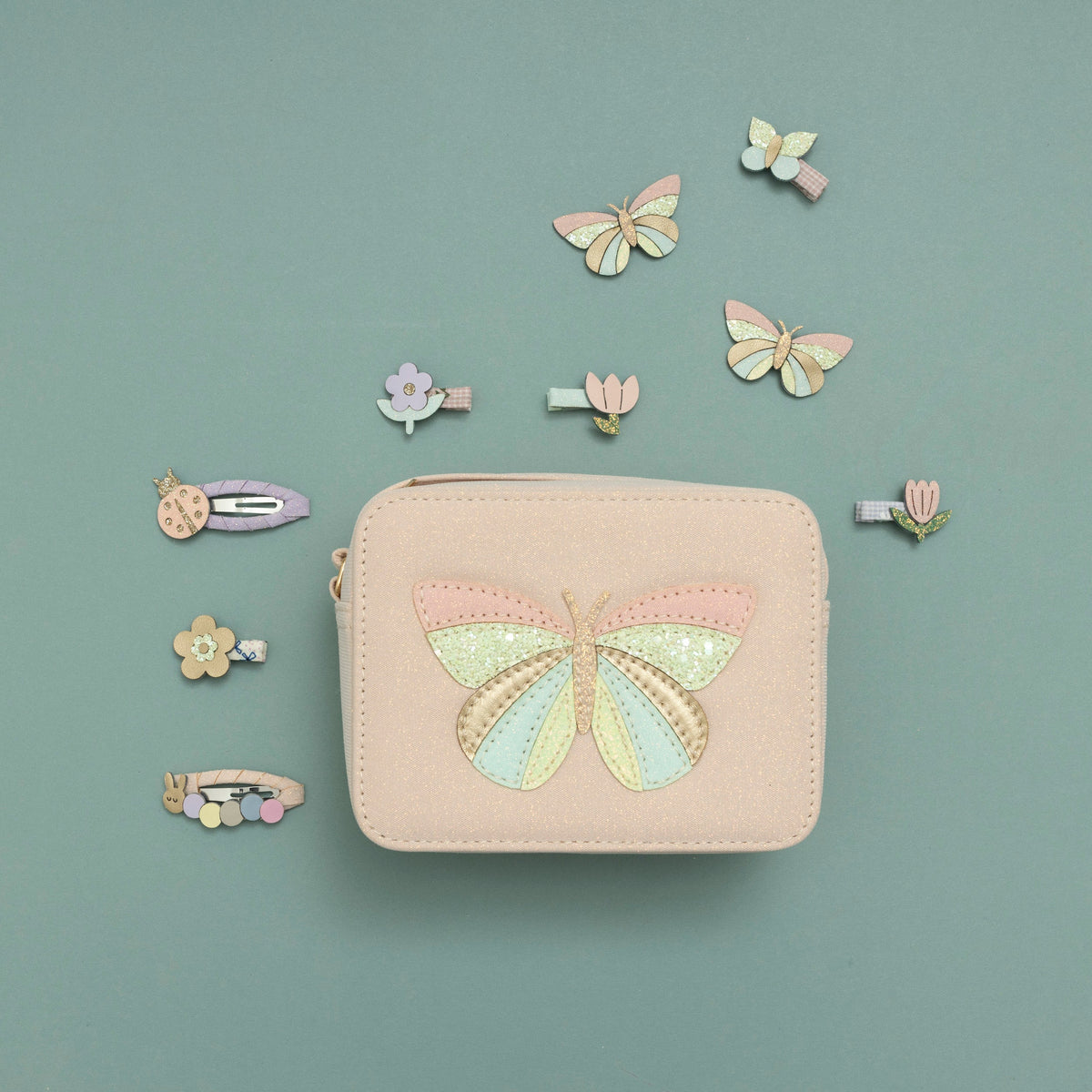 Pastel-colored hair clips and pouch bag arranged on a light blue background