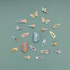 Collection of colorful hair clips and accessories on a teal background