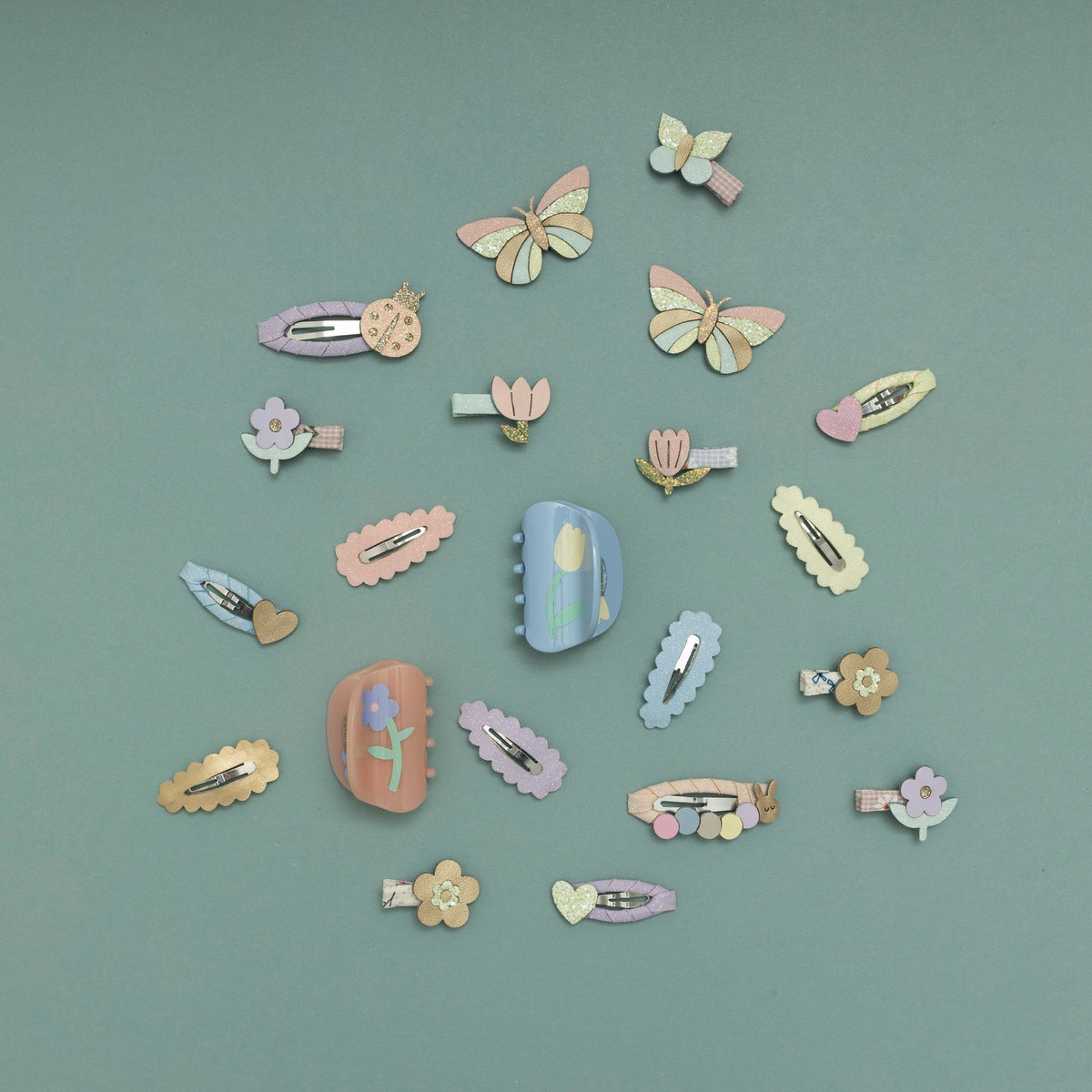 Collection of colorful hair clips and accessories on a teal background