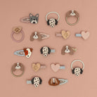 Collection of dog-themed hair accessories on a pink background