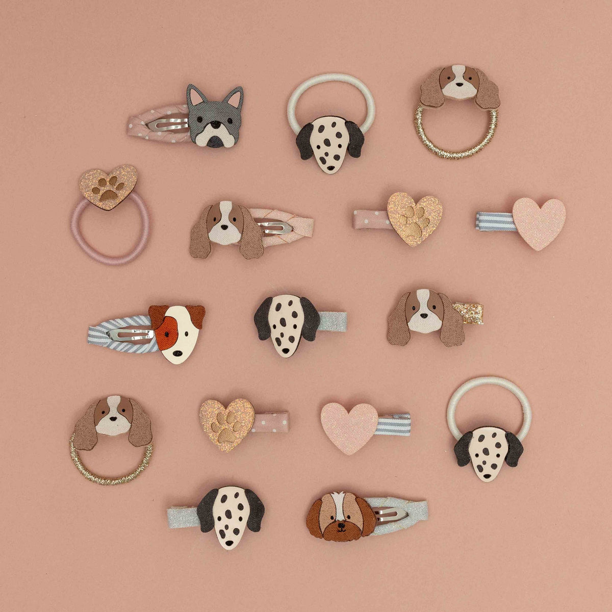 Collection of dog-themed hair accessories on a pink background
