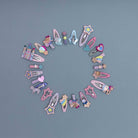 Assorted colorful hair clips arranged in a circular pattern on a gray background