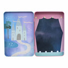 Inside view of the "Enchanted Magnetic Playtime" tin by Floss & Rock, showing two open play scenes with a fairy tale castle on the left and a stage curtain on the right.