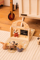 Wooden toy set with animal figures and a chalkboard on a wooden floor.
