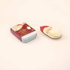 A Christmas-themed scented candle gift set on a warm cream background, featuring a small tin labeled 'Frosty Sugar Salt Candles' and a Santa Claus-shaped candle with a white pom-pom.