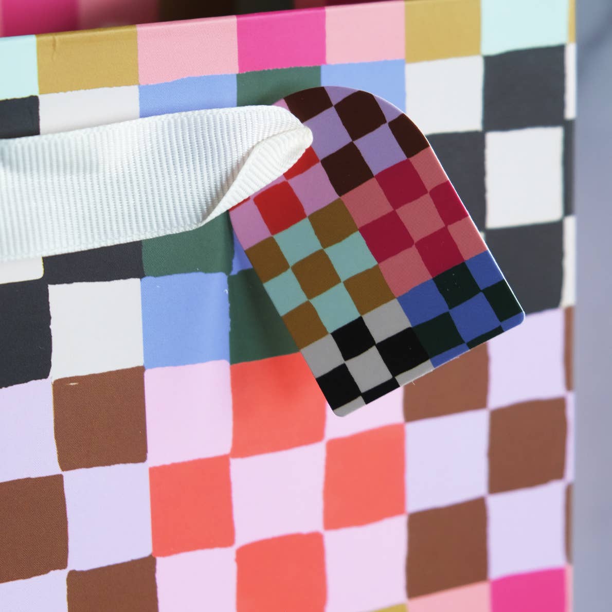 Color swatch book on a multicolored checkered fabric background