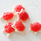 Red and white turtle-shaped candies on a light wooden surface